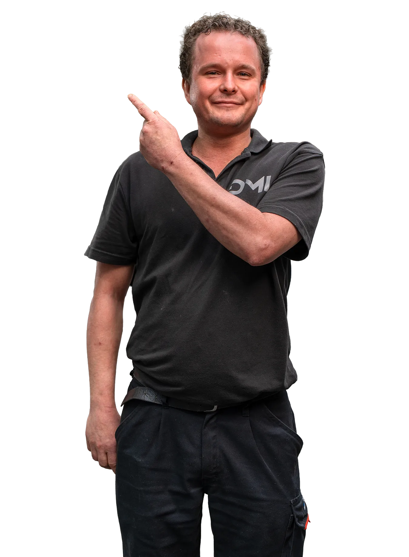 Man met krullend haar in zwart poloshirt en werkbroek wijst met zijn vinger omhoog en kijkt glimlachend naar de camera.