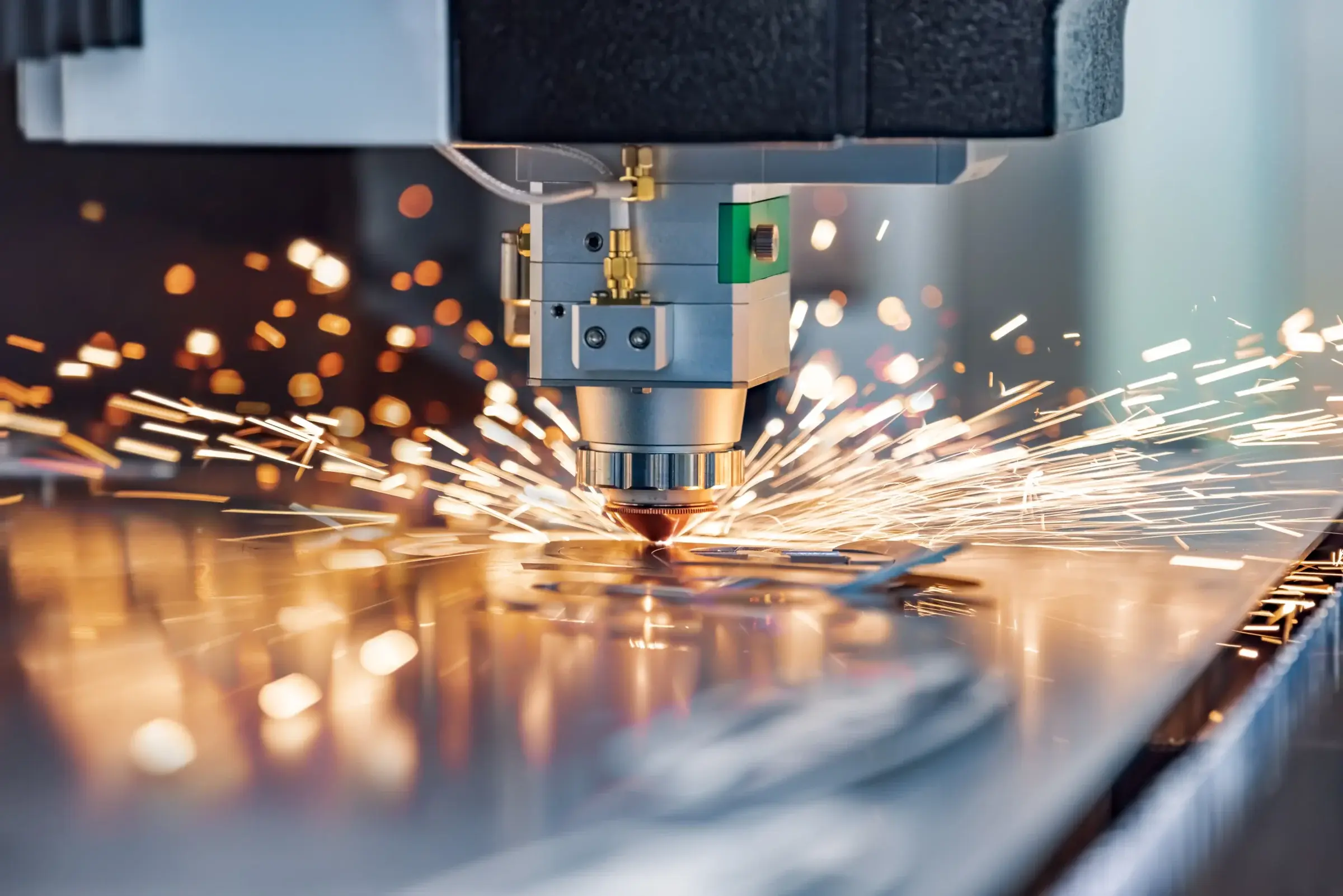 Lasersnijkop snijdt door metalen plaat, met vonken die alle kanten op spatten